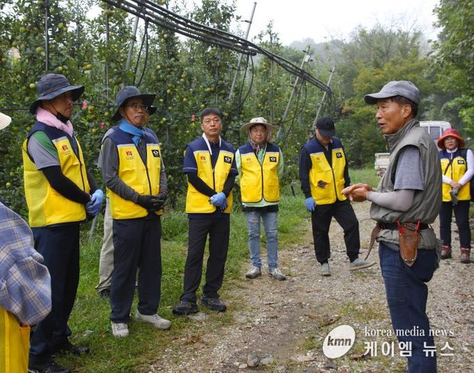 과수원 사장에게 농작업 설명을 듣고 있는 직원 모습