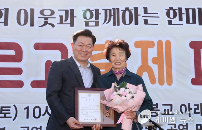 박승원 광명시장이 지난 1일 개봉교 아래 목감천 일대에서 열린 ‘제8회 광명2동 한마당 축제’에 참석해 어르신 환경봉사대 참여 어르신에게 시창 표창을 수여하고 기념사진을 촬영하고 있다.