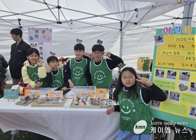 아동창업팀 수공예품 판매 부스에서 아이들이 포즈를 취하고 있다.