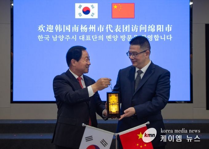 주광덕 남양주시장(좌)이 리원 몐양시장(우)에게 기념품을 전달하고 있다.